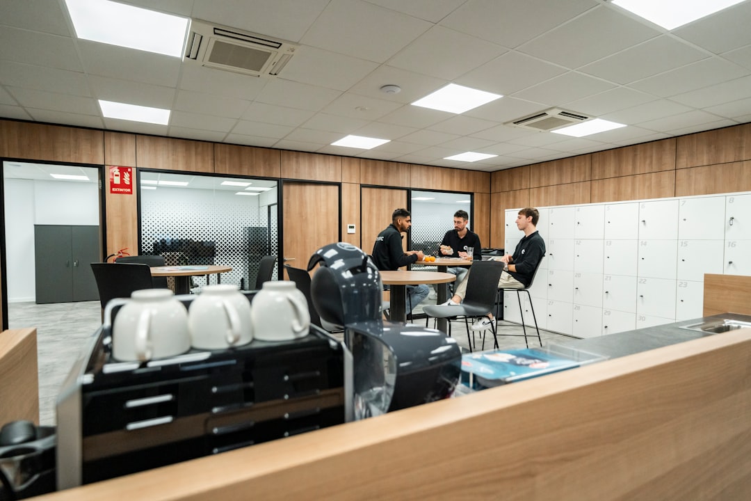 Three people are chatting in a modern office space.