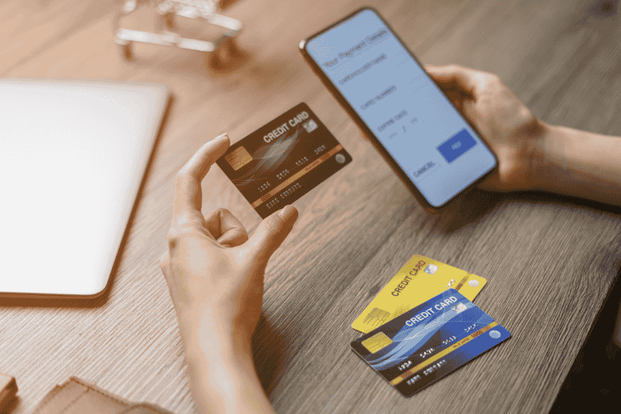 Persona comparando tarjetas de crédito mientras completa datos en una aplicación móvil.