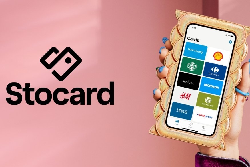 Mano sosteniendo un teléfono con la aplicación Stocard abierta mostrando varias tarjetas de fidelidad.
