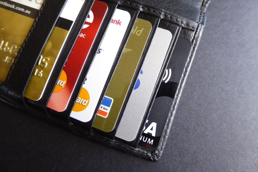 Billetera de cuero negra con varias tarjetas de crédito ordenadas en sus ranuras.