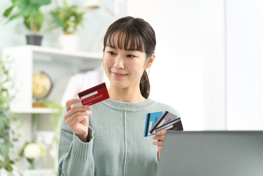 Mujer comparando tarjetas de crédito para elegir la mejor opción en compras grandes