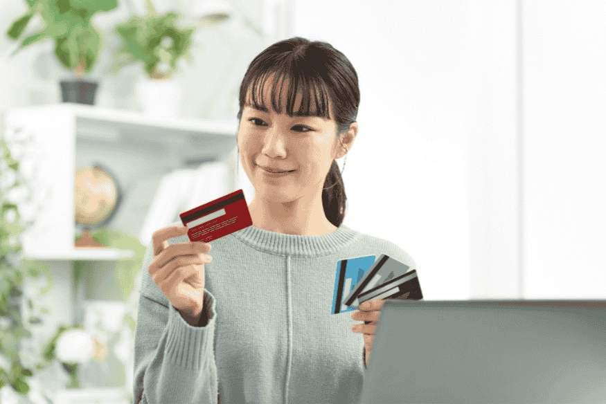 Mujer comparando tarjetas de crédito para elegir la mejor opción en compras grandes