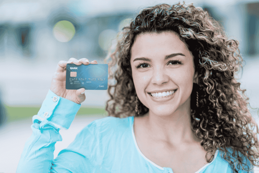 Mujer sonriente mostrando su nueva tarjeta de crédito