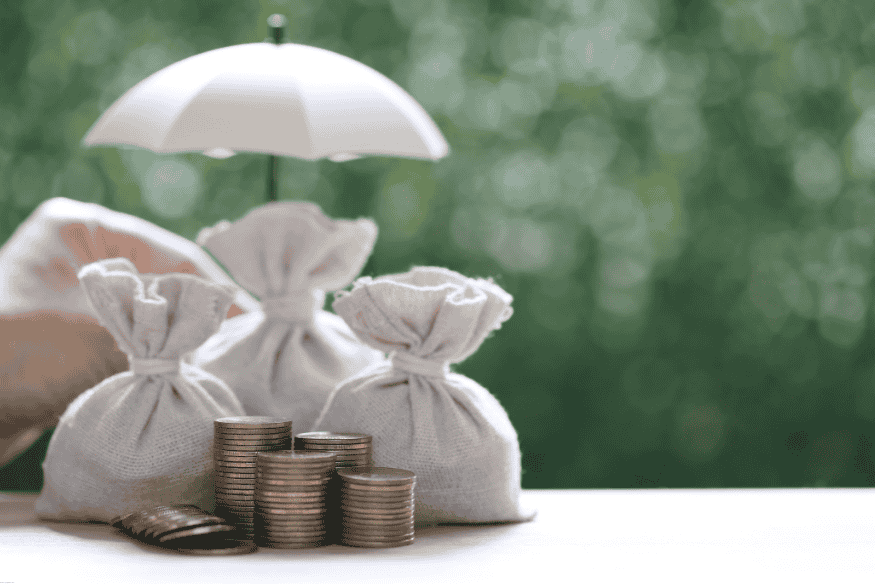 Bolsas de dinero protegidas por una sombrilla blanca, simbolizando ahorro y respaldo financiero.