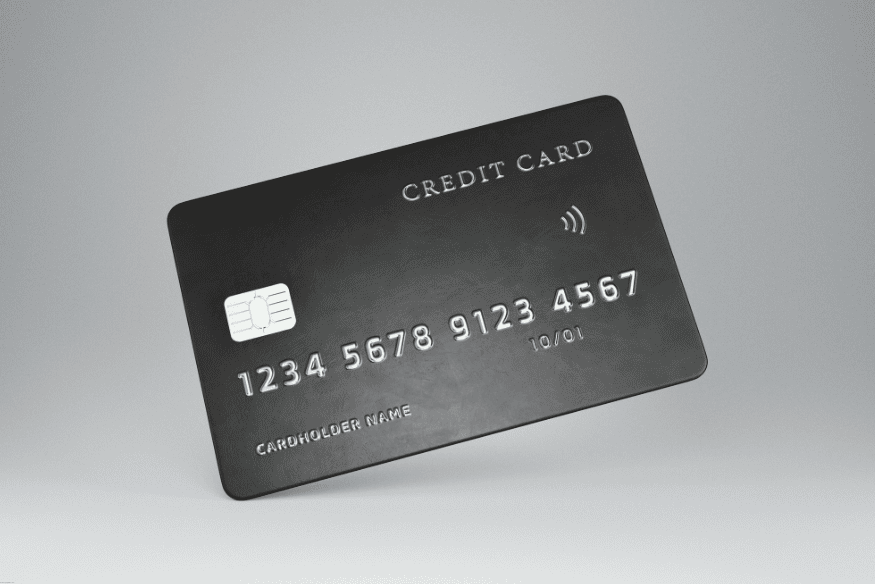 Tarjeta de crédito negra con chip y tecnología contactless, flotando sobre fondo gris claro.