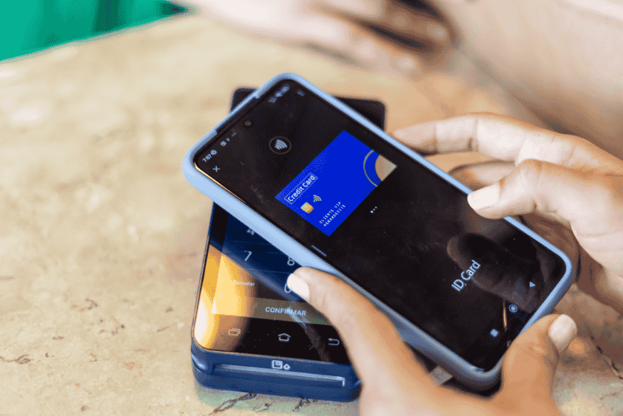 Persona realizando un pago sin contacto usando una tarjeta virtual desde el smartphone.