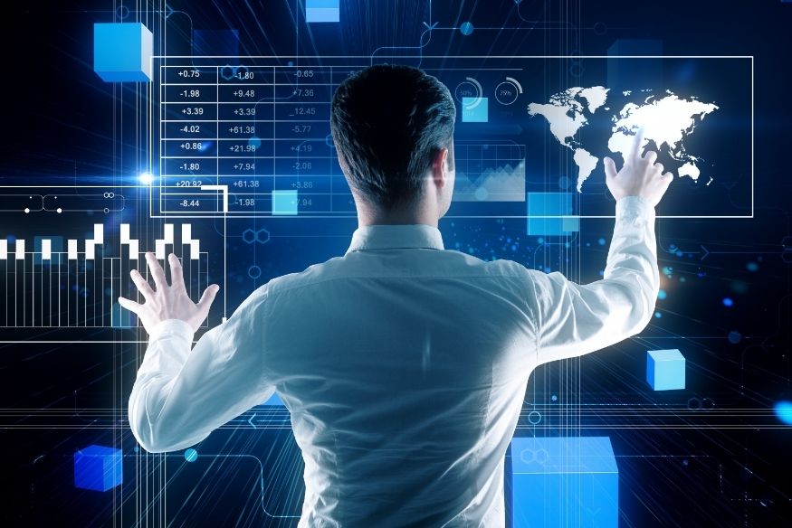Homem interagindo com telas digitais com gráficos financeiros e mapa do mundo.