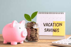 Alcancía y frasco con monedas junto a calendario de ahorro para vacaciones